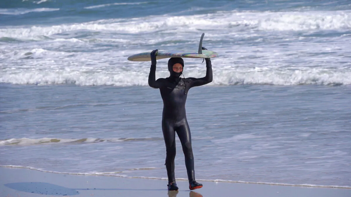 Carter Doorley exits the surf at Brigantine Beach, N.J. after his 1,008th consecutive day surfing on Feb. 26, 2023. (William Huang/The Epoch Times)