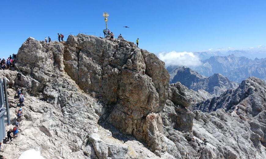 A golden cross marks the top of the 9,700-foot Zugspitze â€“ the highest point in Germany. The mountain straddles the border between Germany and Austria, and lifts from both countries whisk visitors to the top. (Rick Steves)