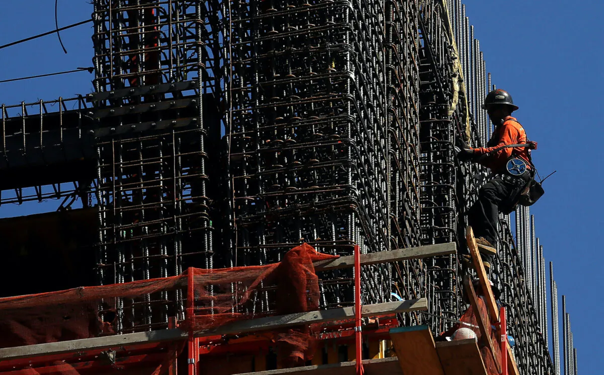 A construction worker hangs from a building under construction in San Francisco on Oct. 5, 2018. (Justin Sullivan/Getty Images)