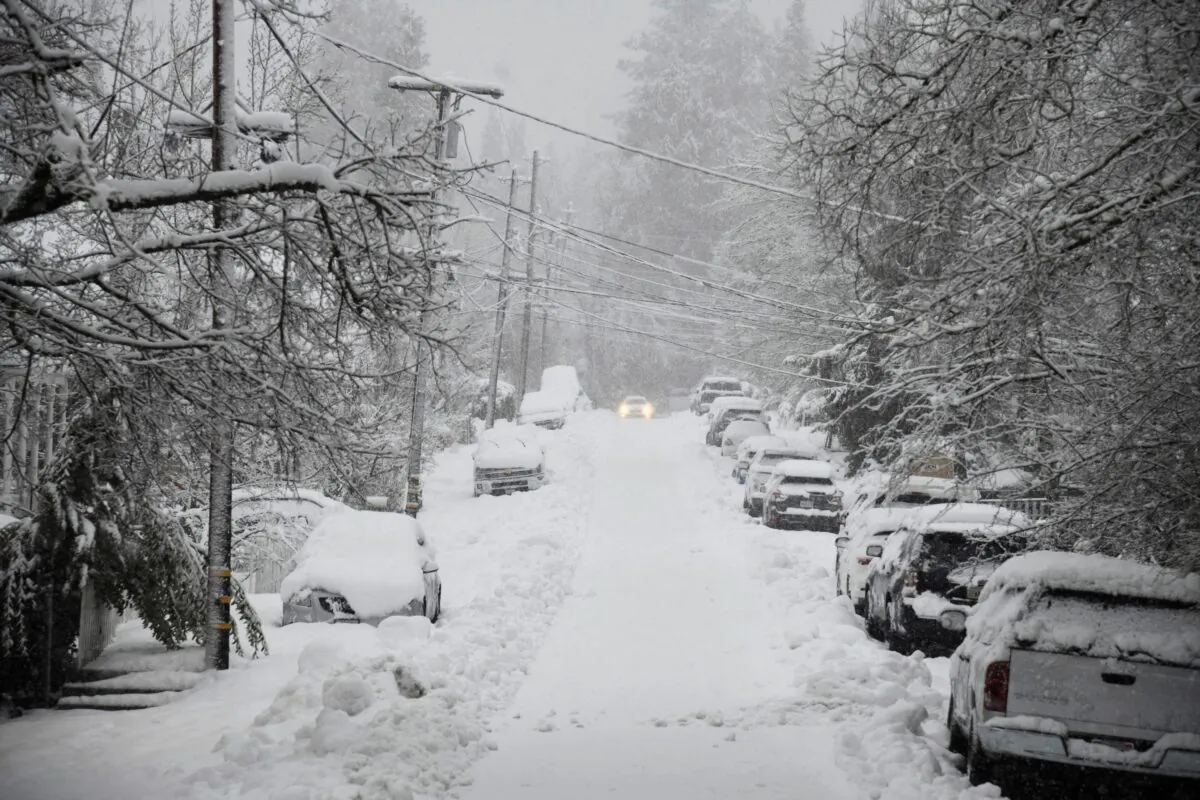 A vehicle attempts to drive along snow-covered Conaway Avenue in downtown Grass Valley, Calif., during a snowstorm, on Feb. 28, 2023. (Elias Funez/The Union via AP)