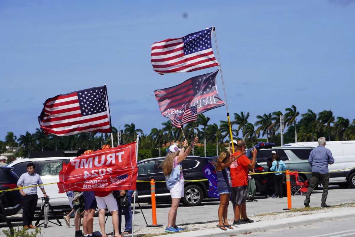 A stalwart cadre of "Bridge People" wave flags, sing patriotic songs, and pray on the Southern Boulevard Bridge near Mar-a-Lago in Palm Beach, Fla., on March 31, 2023. (John Haughey/The Epoch Times)