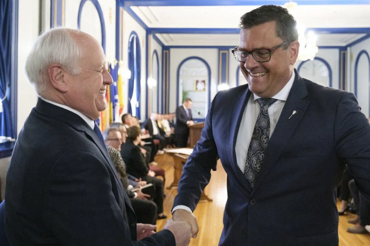 Saskatchewan Agriculture Minister David Marit, left, shakes the hand of Health Minister Paul Merriman, right, at a press conference at Government House in Regina on May 31, 2022 as the government announced a cabinet shuffle. (The Canadian Press/Michael Bell)
