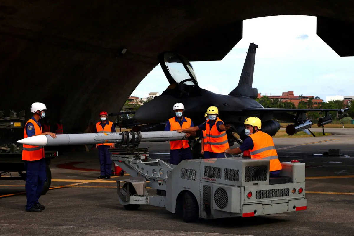 Air force soldiers load a U.S. made AIM-120 Advanced Medium-Range Air-to-Air Missile at a combat readiness mission during a press invited event at the airbase in Hualien, Taiwan, on Aug. 17, 2022. (Ann Wang/Reuters)