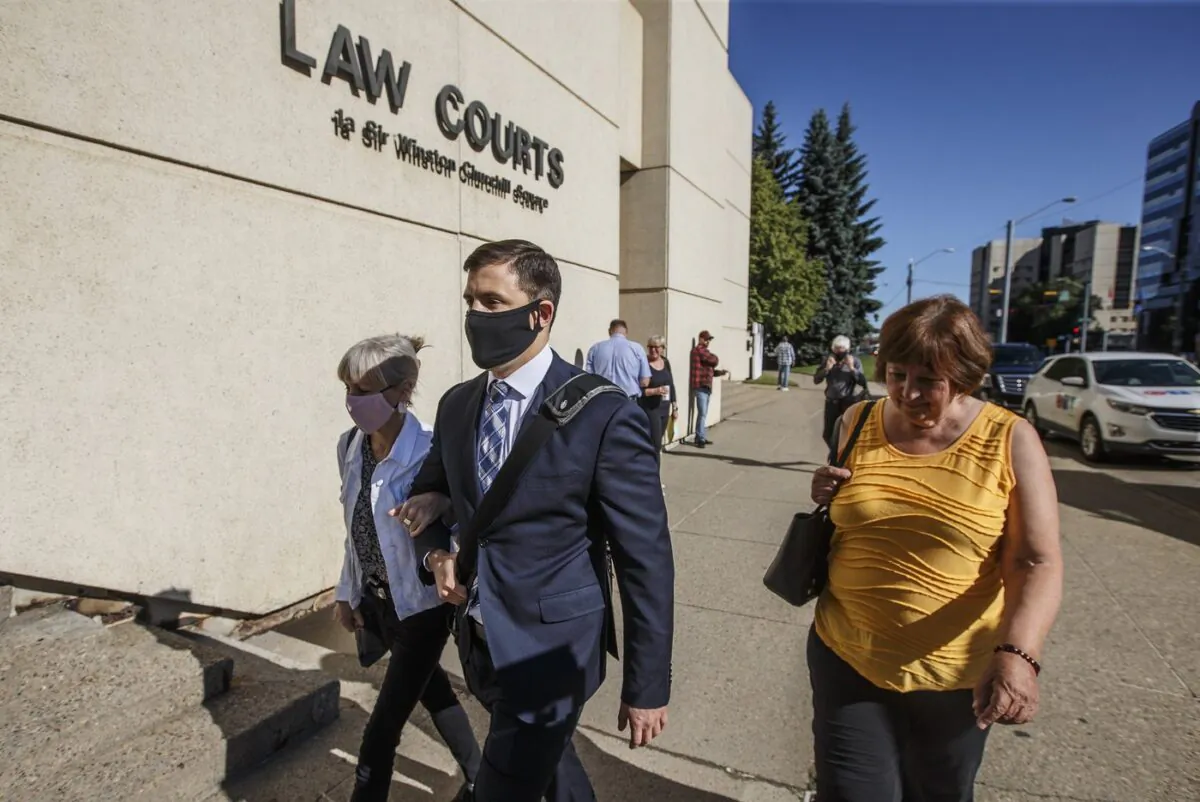 Matthew McKnight holds arms with his mother as they walk into court in Edmonton on July 10, 2020. The Court of Appeal of Alberta has sentenced the former Edmonton club promoter to 11 years for the sexual assaults of five women. (The Canadian Press/Jason Franson)