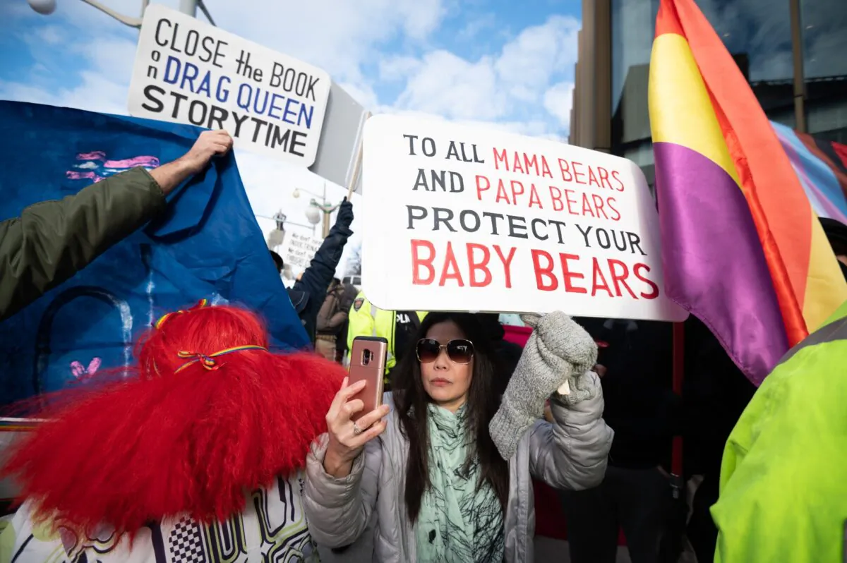 Protesters hold signs outside a "Drag Story Time" event hosted by Capital Pride and the Ottawa Public Library in Ottawa, on Feb. 8, 2023. (Spencer Colby/The Canadian Press)