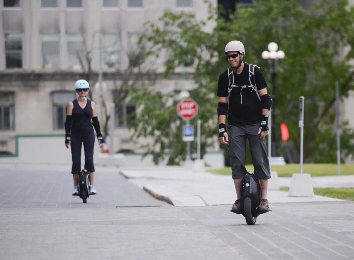 People ride electric unicycles on Parliament Hill in Ottawa on July 22, 2020.  (The Canadian Press/Sean Kilpatrick)