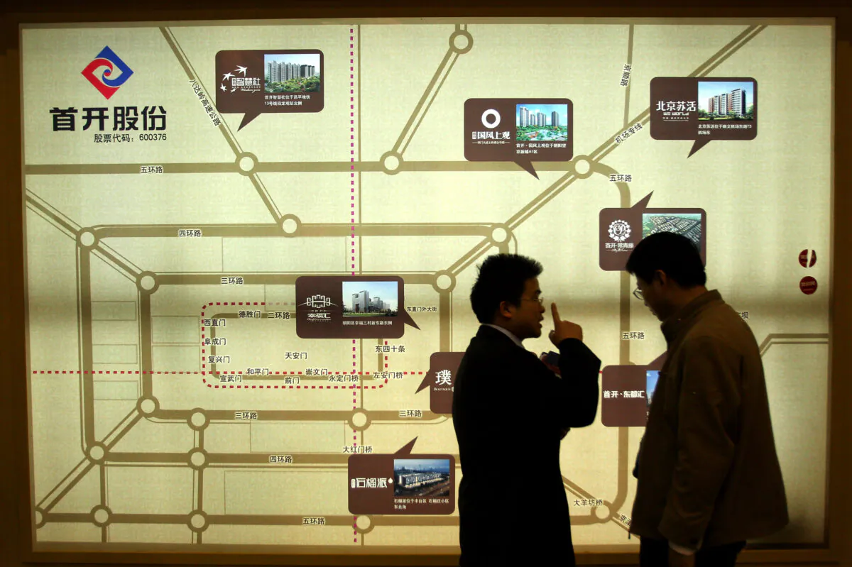 A sales person introduces properties to a potential buyer at the 2010 Beijing Spring Real Estate Trade Fair on April 10, 2010 in Beijing, China. (Feng Li/Getty Images)