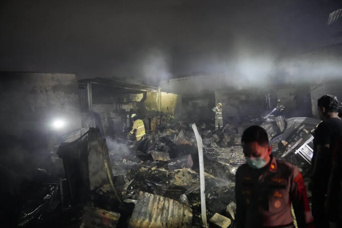 Firefighters inspect the ruins of houses destroyed in a fire in Jakarta, Indonesia, on March 3, 2023. (Dita Alangkara/AP Photo)