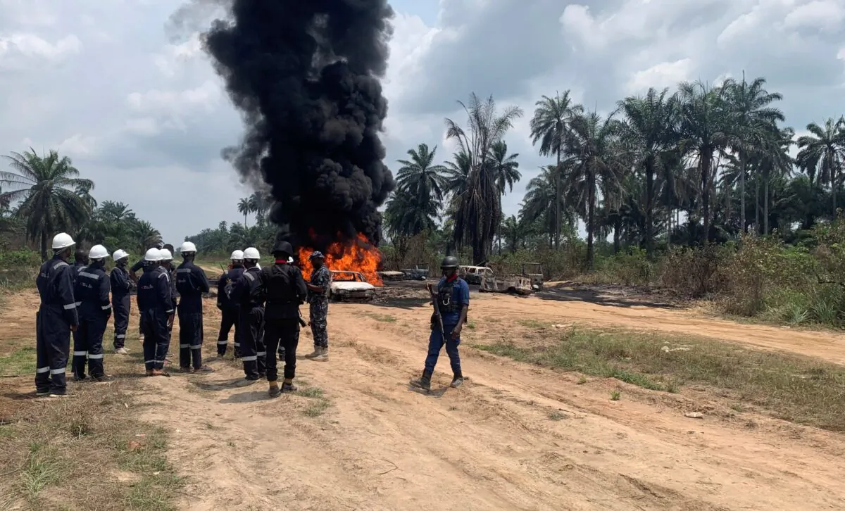 Fire fighters and security officers are seen at the site of an illegal refinery explosion In Emuoha council area of the southern Rivers, Nigeria, on March 3, 2023. (AP Photo)