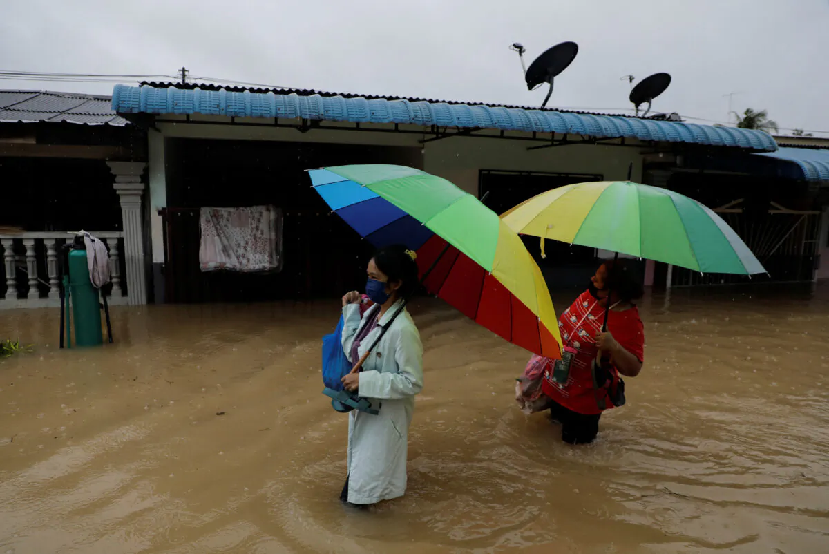 People wade through a flooded residential area at Yong Peng, Johor, Malaysia, on March 4, 2023. (Hasnoor Hussain/Reuters)