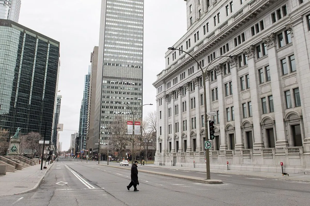 A man crosses an empty street in downtown Montreal during nationwide lockdowns at the beginning of the pandemic, on April 5, 2020. (The Canadian Press/Graham Hughes)