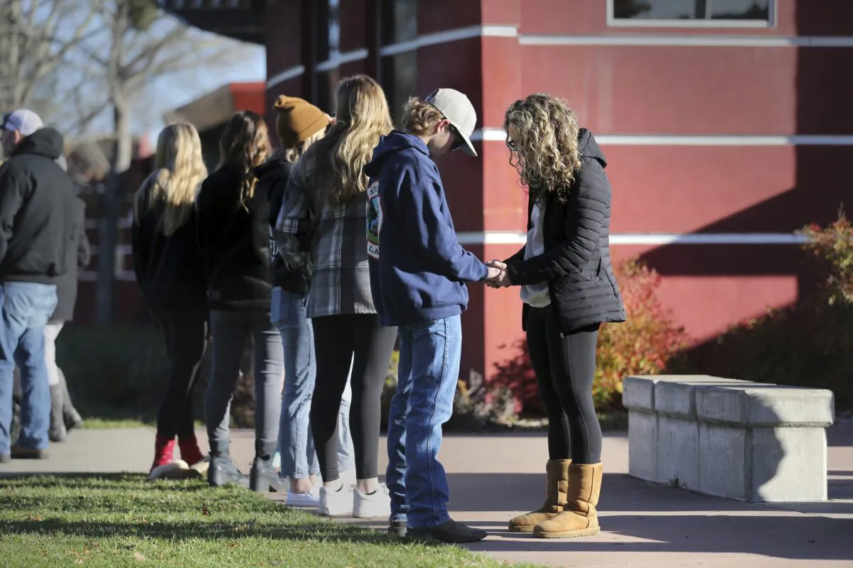 Natalie Goodrich, a member of New Vintage Church, prays with Montgomery High student Cameron Gonzalez, 15, near the flag pole at the school in Santa Rosa, Calif., on March 2, 2023. (Beth Schlanker/The Press Democrat via AP)