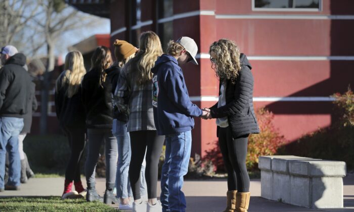 Natalie Goodrich, a member of New Vintage Church, prays with Montgomery High student Cameron Gonzalez, 15, near the flag pole at the school in Santa Rosa, Calif., on March 2, 2023. (Beth Schlanker/The Press Democrat via AP)