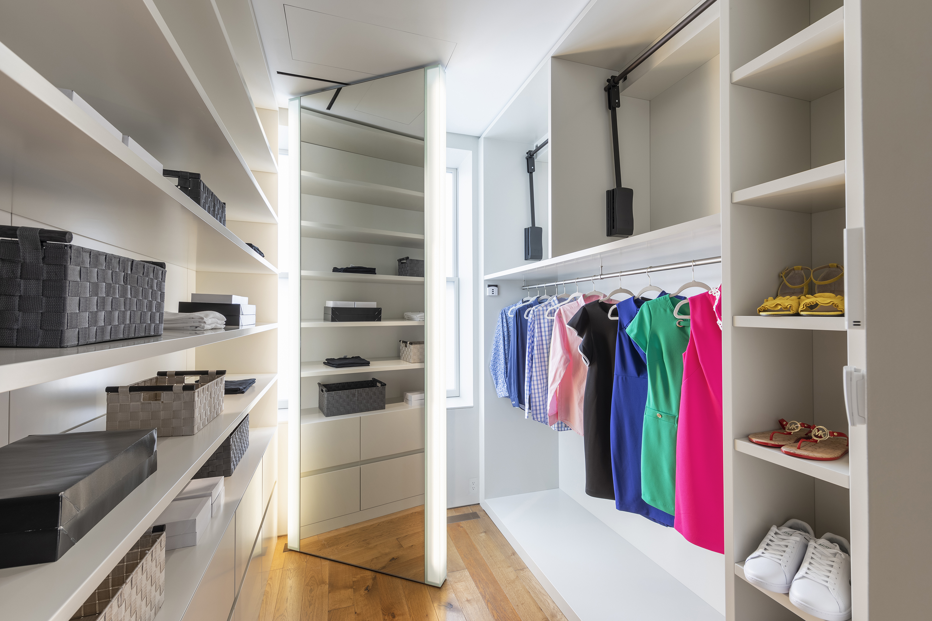 Bins and boxes add to the organization in a primary bedroom closet.