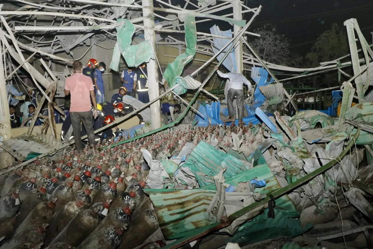 Firefighters and rescue workers gather at the site of an explosion at an oxygen plant on the outskirts of Chittagong, Bangladesh, on March 4, 2023. (AFP via Getty Images)
