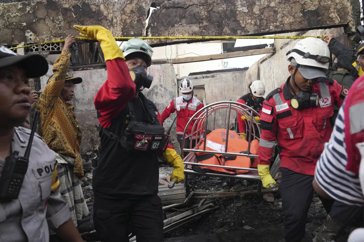 Rescuers recover the body of a victim from a neighborhood affected by a fuel depot fire in Jakarta, Indonesia, on March 4, 2023. (Tatan Syuflana/AP Photo)