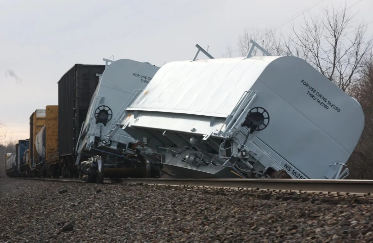 A Norfolk Southern cargo train car leans off the tracks after derailing in Clark County, Ohio, at a train crossing with Ohio 41 on March 4, 2023. (Bill Lackey/Springfield-News Sun via AP)