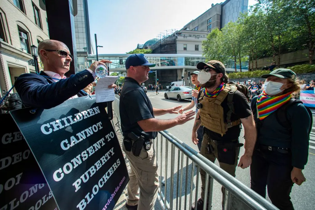 Police stand between anti-trans activist Chris Elston (L) and counterprotestors (R) as they confront each other outside of Boston Childrens Hospital in Boston, Mass., on Sept. 18, 2022. (Joseph Prezioso/AFP via Getty Images)