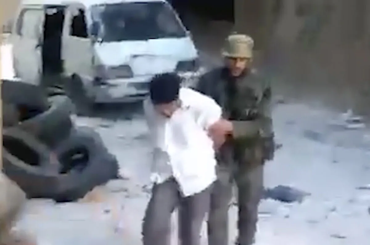 A blindfolded Syrian man is pushed by a Syrian agent before he was shot dead and thrown into a large pit full of bodies in the Tadamon neighborhood of Damascus, Syria, in a frame grab from a 2013 video. (AP Photo)