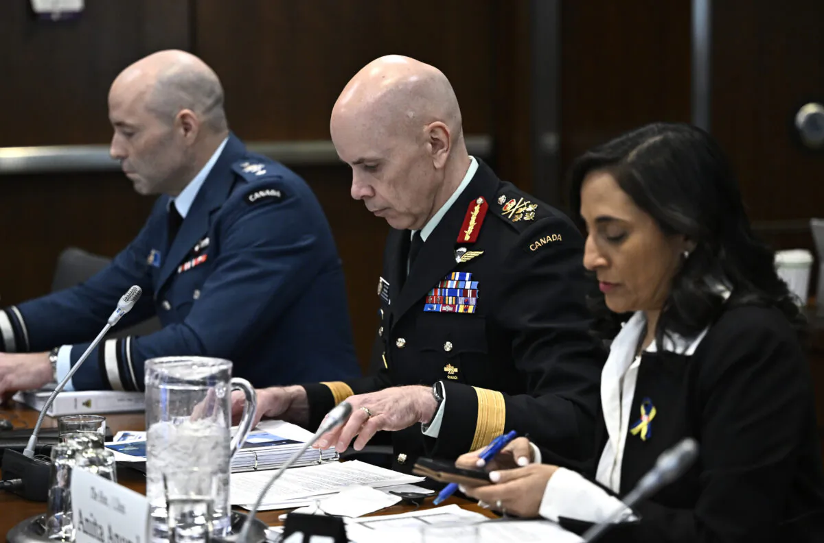 Gen. Wayne Eyre, chief of Defence Staff, looks at his notes as he prepares to appear as a witness at the Standing Committee on National Defence, regarding the surveillance balloon from China, along with Minister of National Defence Anita Anand (R) in Ottawa, on March 7, 2023. (Justin Tang/The Canadian Press)