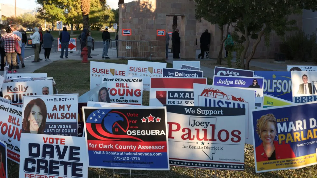 Campaign signs are shown near voters waiting in line at Desert Breeze Community Center on Election Day in Las Vegas, Nev., on Nov. 8, 2022. (Ronda Churchill/AFP via Getty Images)