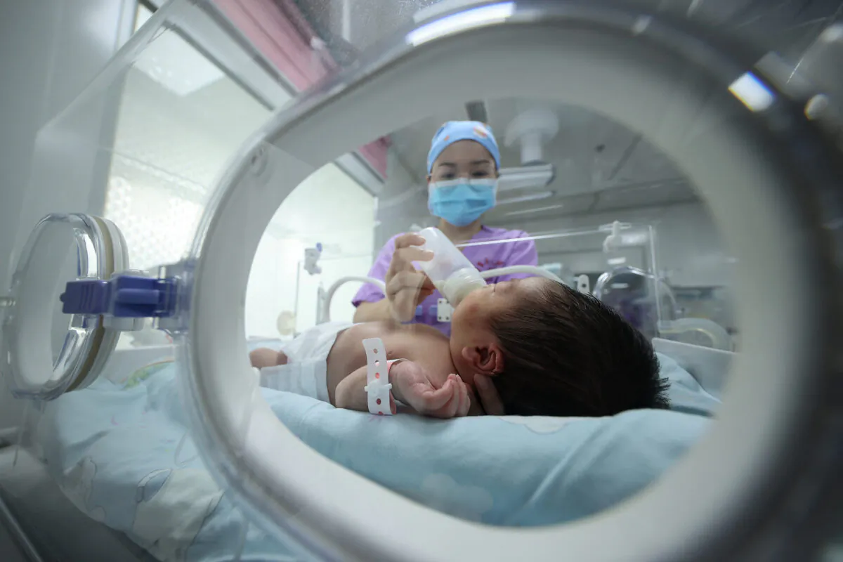 A medical staffer feeds a baby at a hospital in Danzhai, in China's southwestern Guizhou Province, on May 11, 2021. (STR/AFP via Getty Images)