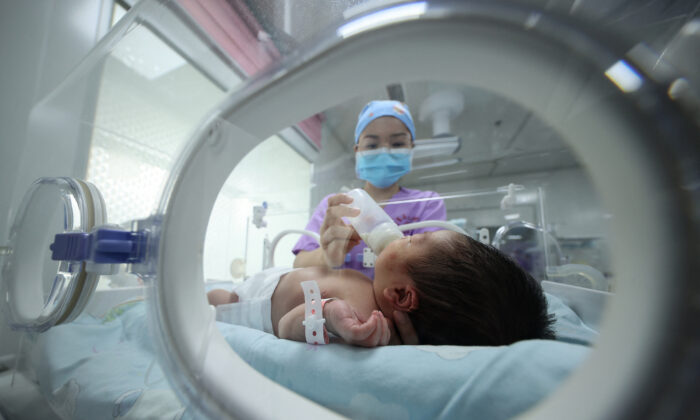 A medical staffer feeds a baby at a hospital in Danzhai, in China's southwestern Guizhou Province, on May 11, 2021. (STR/AFP via Getty Images)