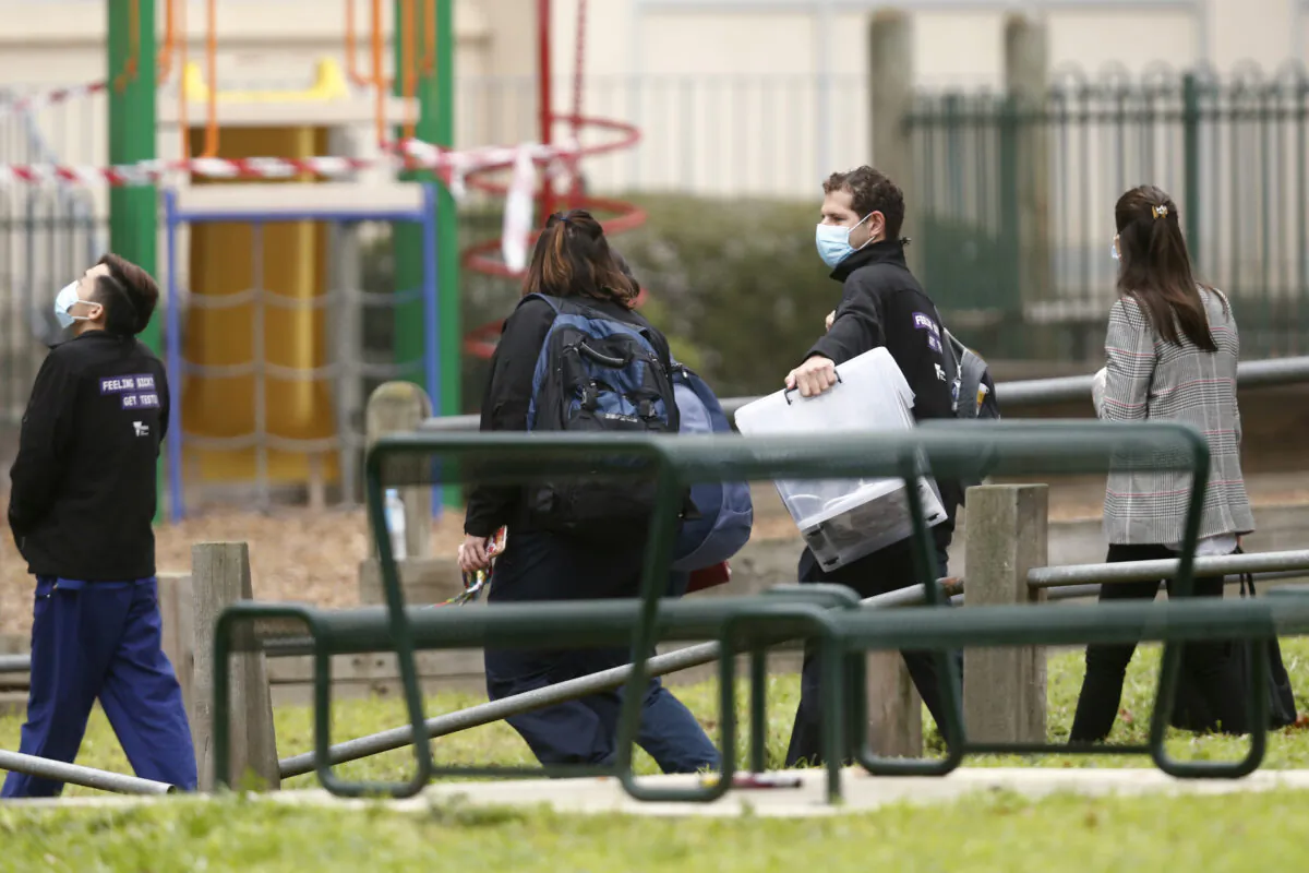 Government employees are seen entering the Alfred Street Public Housing Complex in Melbourne, Australia, on July 17, 2020. (Darrian Traynor/Getty Images)