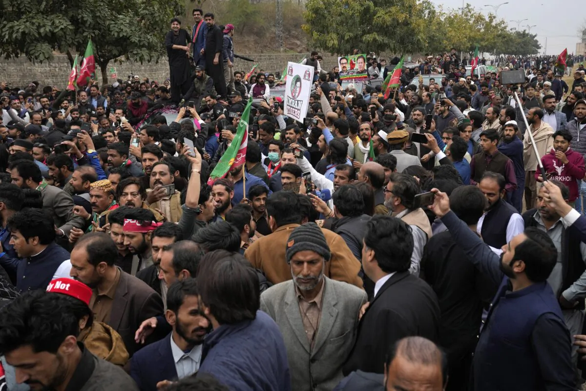Supporters of former Pakistani Prime Minister Imran Khan move with a vehicle (C), carrying their leader Khan arriving for his court appearance, in Islamabad, Pakistan, on Feb. 28, 2023. (Anjum Naveed/AP Photo)