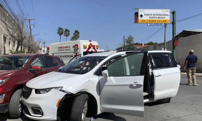A member of the Mexican security forces stands next to a white minivan with North Carolina plates and several bullet holes, at the crime scene where gunmen kidnapped four U.S. citizens who crossed into Mexico from Texas, on March 3, 2023. (AP Photo)