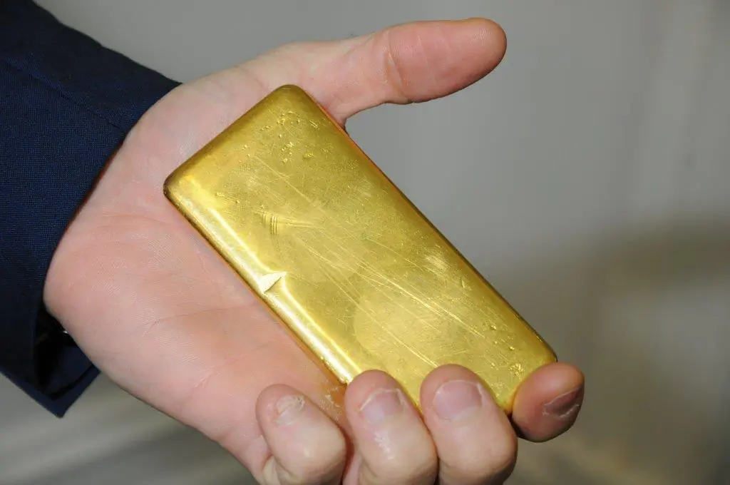 A supplied image obtained Friday, May 5, 2017 of Detective Senior Constable Jared Pragnell from the Gold Stealing Detection Unit holding a 1kg gold bar. (AAP Image/Western Australia Police)