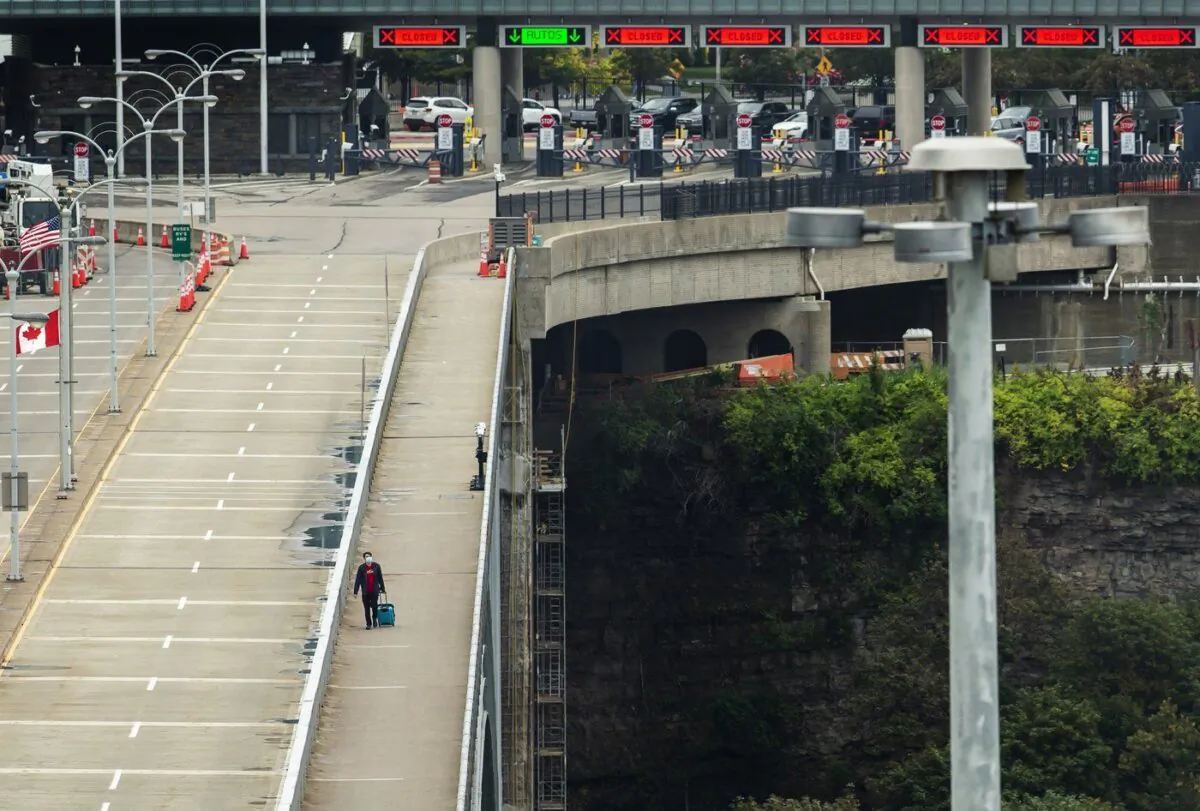 A person crosses the International Rainbow Bridge from Niagara Falls, N.Y. into Niagara Falls, Ont. on Oct. 13, 2021. (The Canadian Press/Aaron Lynett)