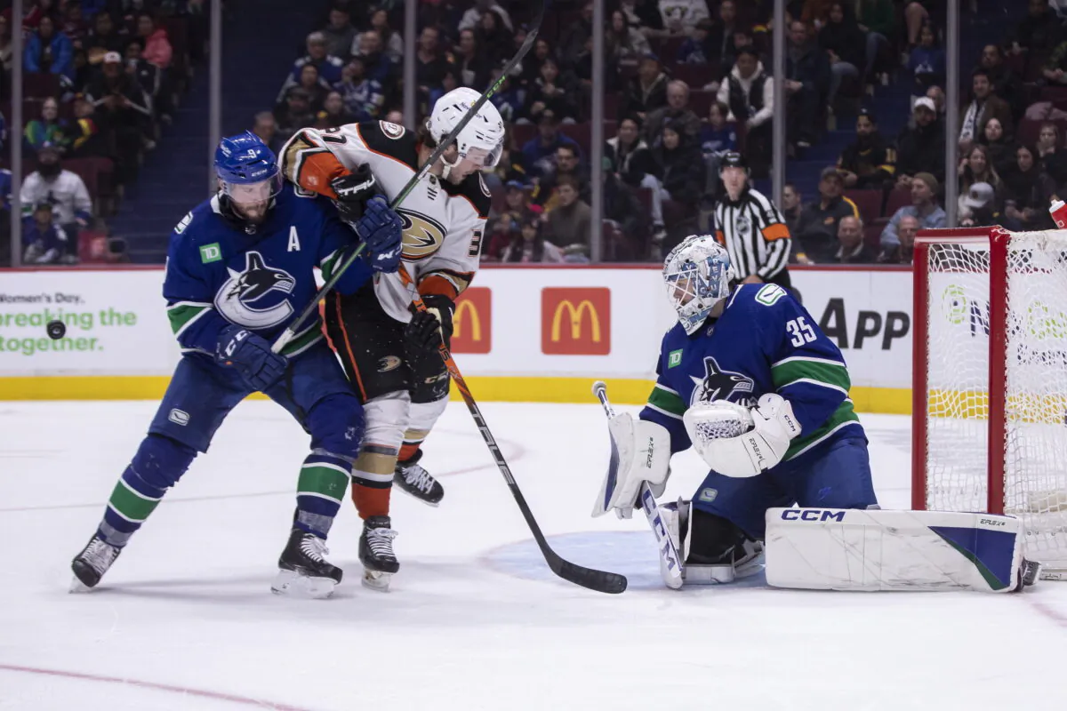 Vancouver Canucks goaltender Thatcher Demko (35) makes a save against Anaheim Ducks' Mason McTavish (37) as Canucks' J.T. Miller (9) defends during the third period of an NHL hockey game in Vancouver, British Columbia, on March 8, 2023. (Ben Nelms/The Canadian Press via AP)