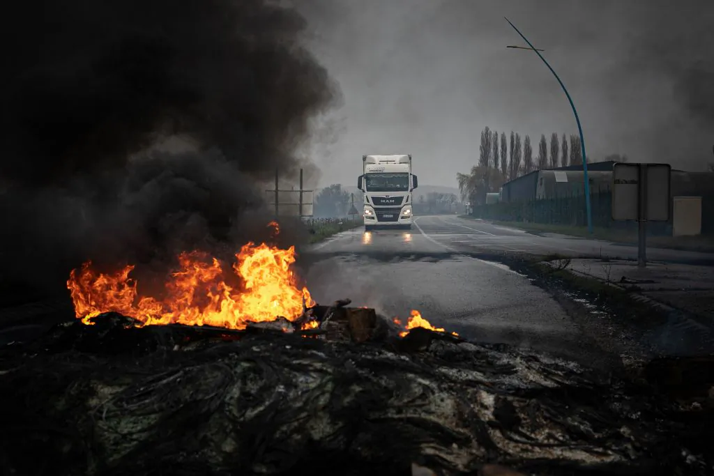 This photograph taken on March 8, 2023 shows a truck driving towards a fire on the Radicatel Terminal of the harbour in Port Jerome sur Seine in France. (Lou Benoist/AFP via Getty Images)