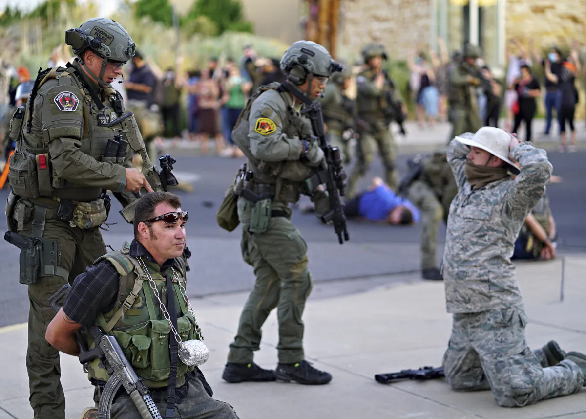 Albuquerque police detain members of the New Mexico Civil Guard, an armed civilian group, following the shooting of a man during a protest over a statue of Spanish conquerer Juan de Oñate in Albuquerque, N.M. on June 15, 2020. (Adolphe Pierre-Louis/The Albuquerque Journal via AP/File)