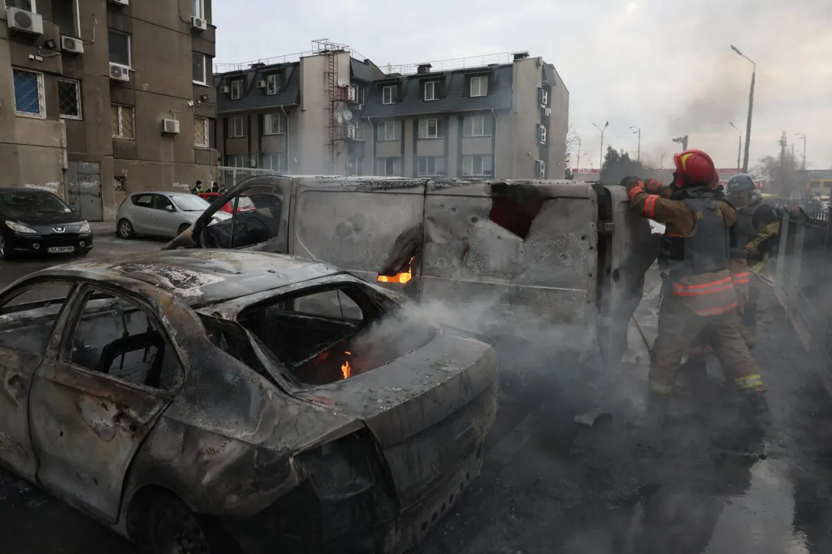 Emergency workers extinguish fire in vehicles at the site of a Russian missile strike, amid Russia’s attack on Ukraine, in Kyiv, Ukraine, on March 9, 2023. (Gleb Garanich/Reuters)