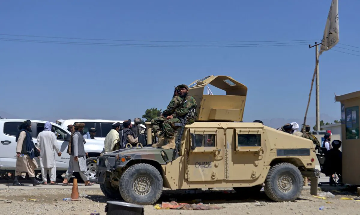 Members of the Taliban wait to enter the former U.S. military base to celebrate the first anniversary of the withdrawal of U.S.-led troops from Afghanistan, in Bagram, Afghanistan, on Aug. 31, 2022. (Ahmad Sahel Arman/AFP via Getty Images)