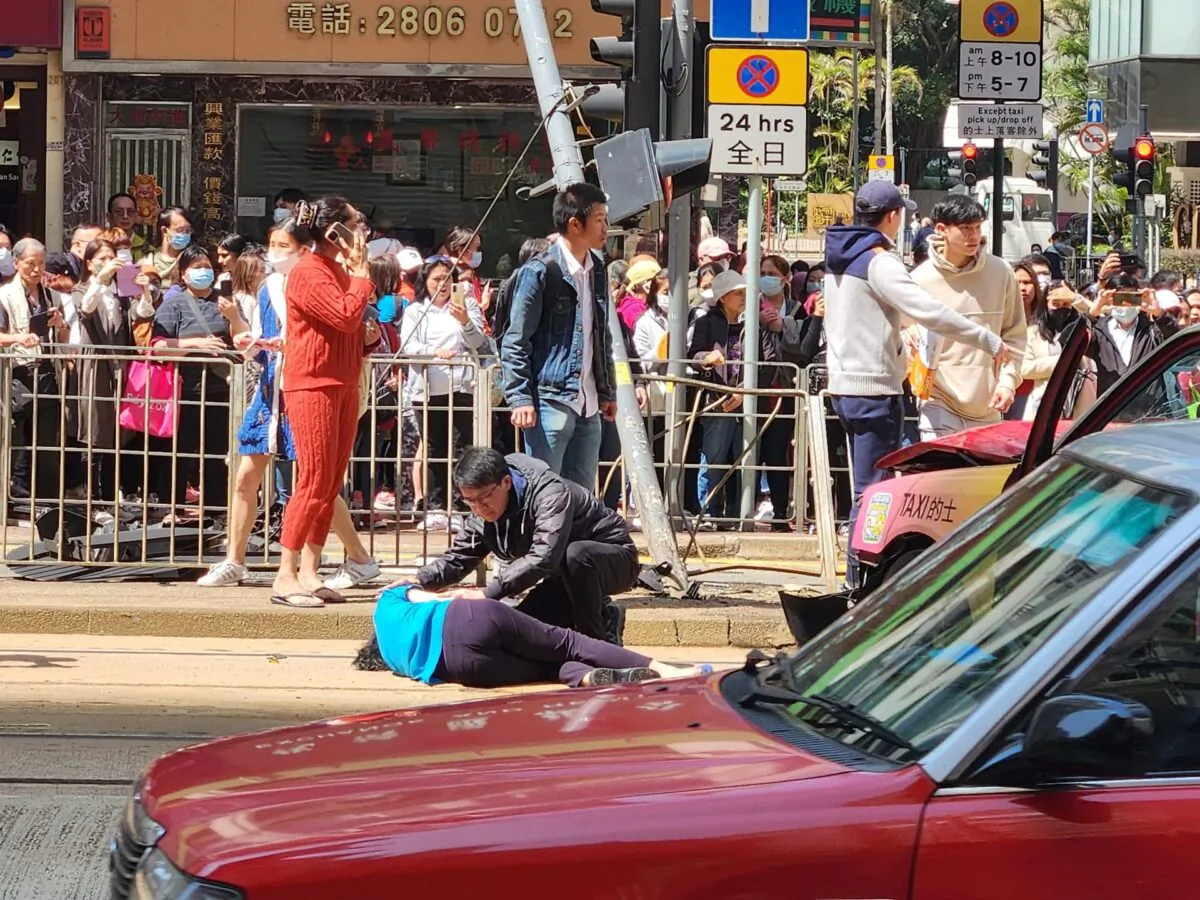 A taxi ploughed into pedestrians at a crossing point of Fortress Hill, and slammed into a traffic light on a busy Hong Kong road on Feb. 5. The 84-year-old taxi driver was arrested after the three people were found to be injured, two critically, (Courtesy of Channel C)