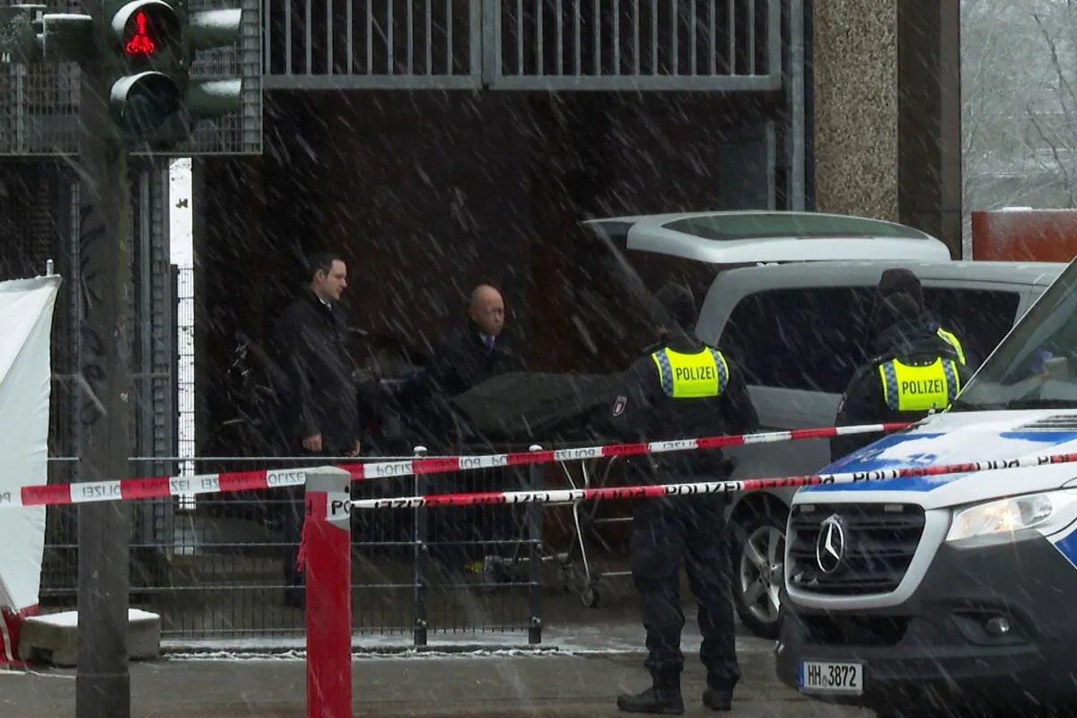 Morticians bring a covered stretcher to their vehicle at a building used by Jehovah's Witnesses in Hamburg, Germany, on March 10, 2023. (Steven Hutchings/Tnn/dpa via AP)