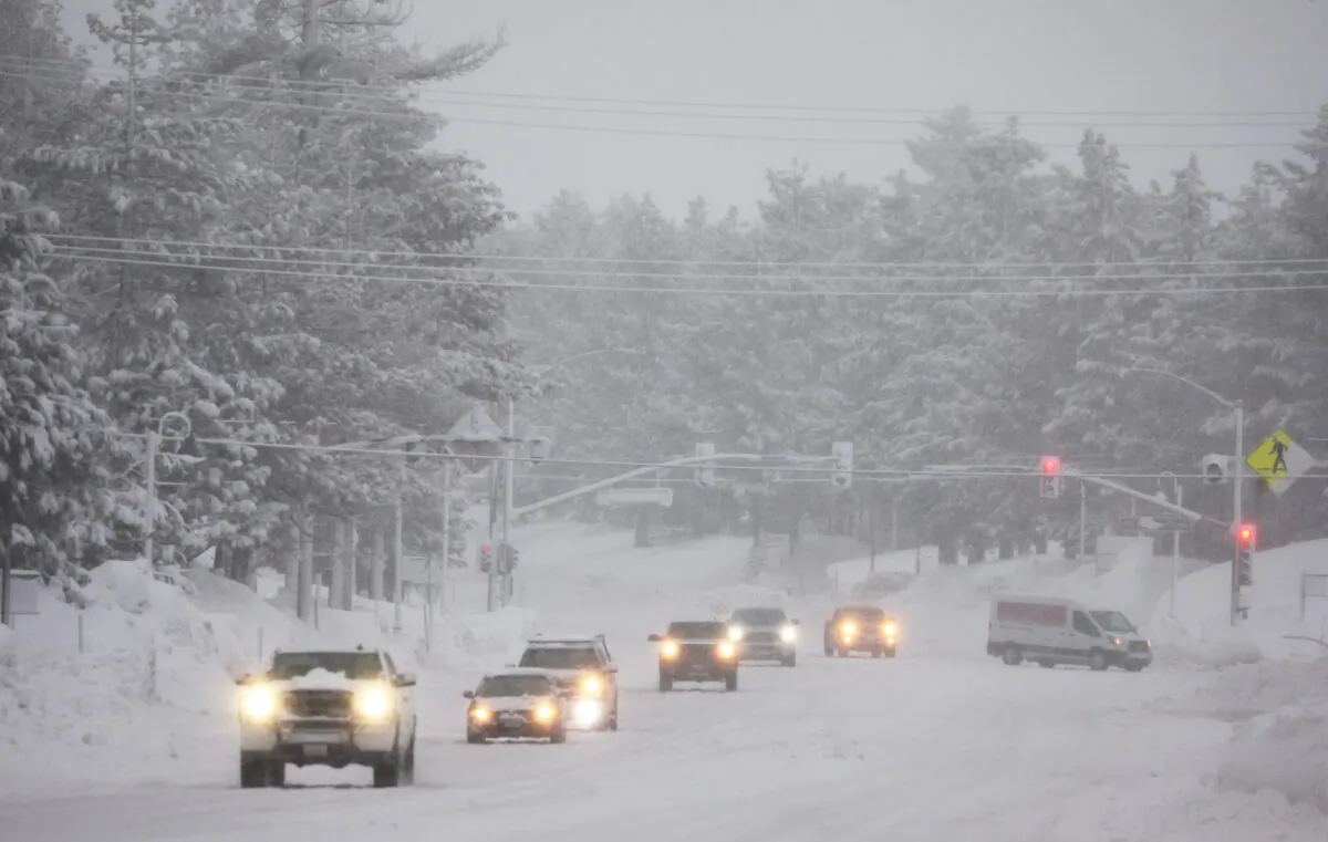 Vehicles drive as snow falls during another winter storm in the Sierra Nevada mountains in Mammoth Lakes, California, on March 10, 2023. (Mario Tama/Getty Images)