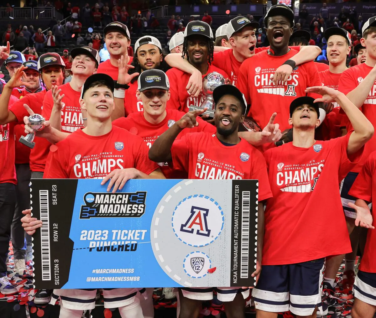 The Arizona Wildcats, including (front, L-R) Pelle Larsson (3), Azuolas Tubelis (10), Courtney Ramey (0) and Kerr Kriisa (25), pose with a ceremonial NCAA tournament ticket as they celebrate their 61–59 victory over the UCLA Bruins to win the championship game of the Pac-12 basketball tournament at T-Mobile Arena in Las Vegas on March 11, 2023. (Ethan Miller/Getty Images)