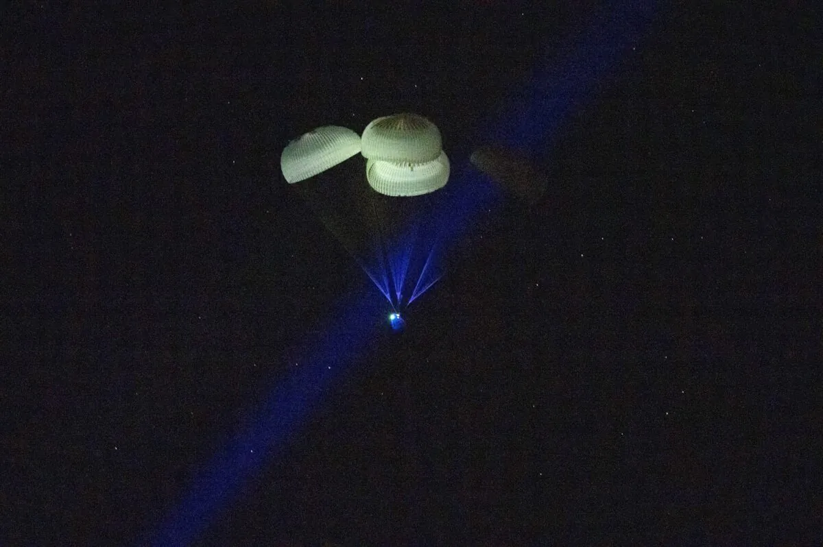 The capsule of the SpaceX Dragon Endurance spacecraft, slowed by parachutes, approaches the surface of the waters of the Gulf of Mexico off Tampa, Fla., as it returns to Earth on March 11, 2023. (Keegan Barber/NASA via AP)