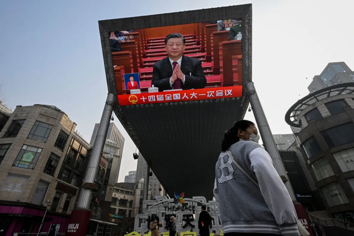 An outdoor screen shows a live news coverage of Chinas President Xi Jinping during the opening session of the National People's Congress (NPC) at the Great Hall of the People, along a street in Beijing on March 5, 2023. (Jade Gao/AFP via Getty Images)