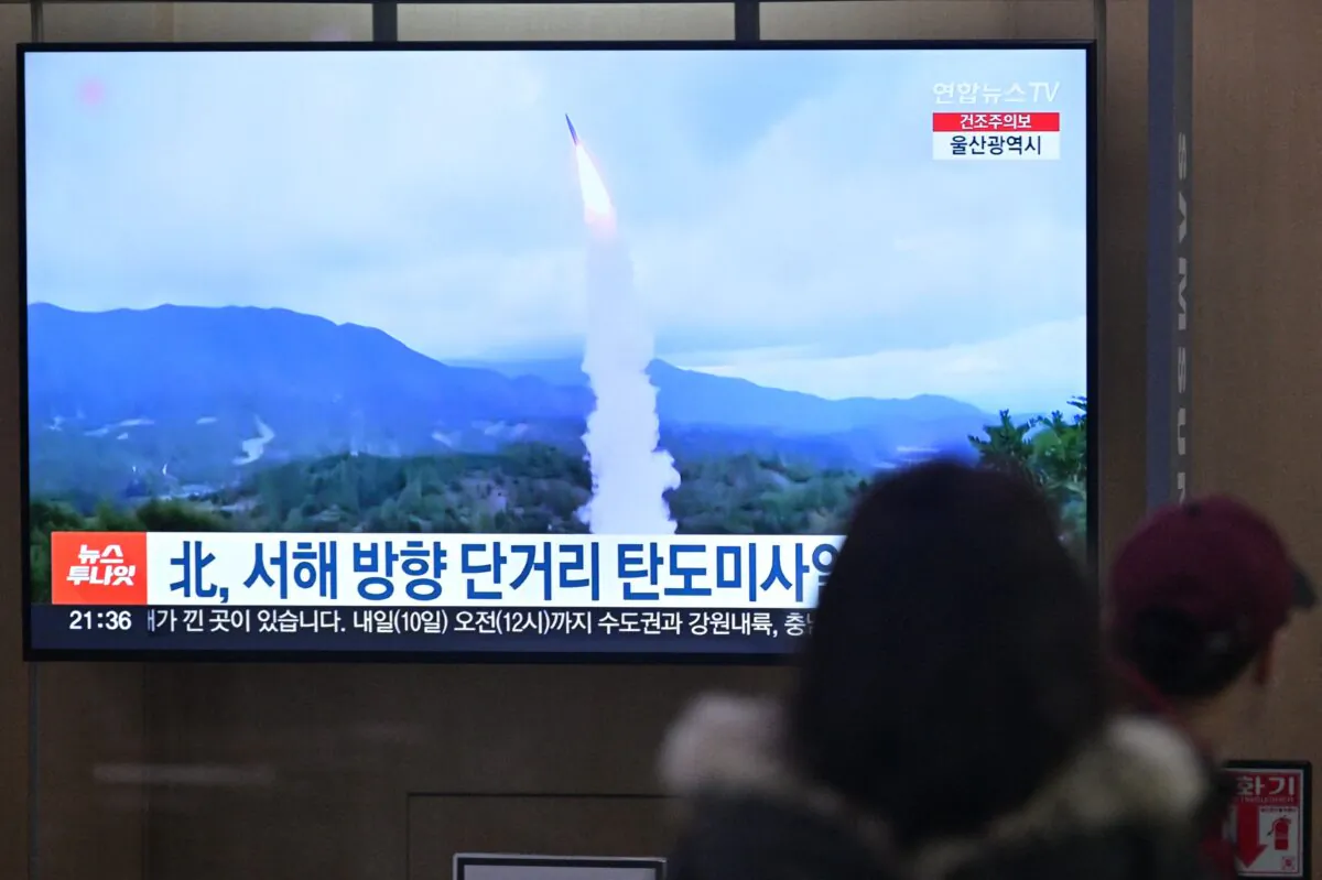 People sit near a television showing a news broadcast with file footage of a North Korean missile test, at a railway station in Seoul, on March 9, 2023. (Anthony Wallace/AFP via Getty Images)