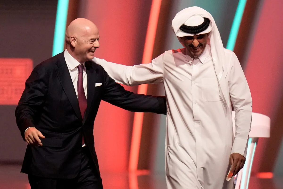 FIFA President Gianni Infantino (L), and Emir of Qatar Sheikh Tamim bin Hamad Al Thani leave the stage before the 2022 soccer World Cup draw at the Doha Exhibition and Convention Center in Doha, Qatar, on April 1, 2022. (Hassan Ammar/AP Photo)