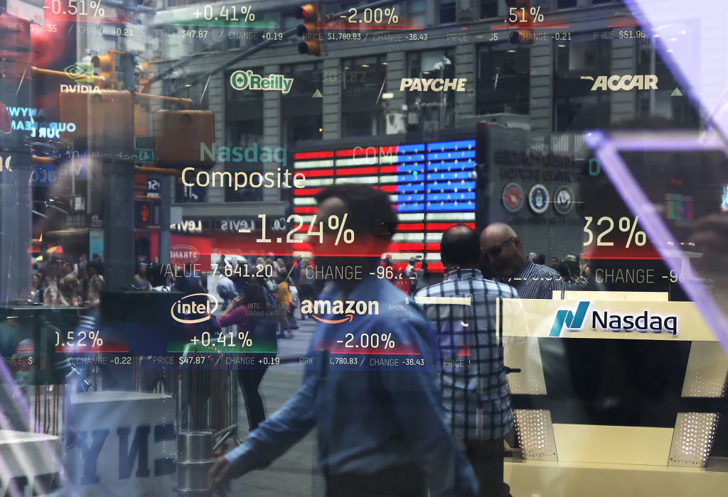 People are reflected in a window of the Nasdaq MarketSite in New York's Time Square, on July 30, 2018. (Spencer Platt/Getty Images)