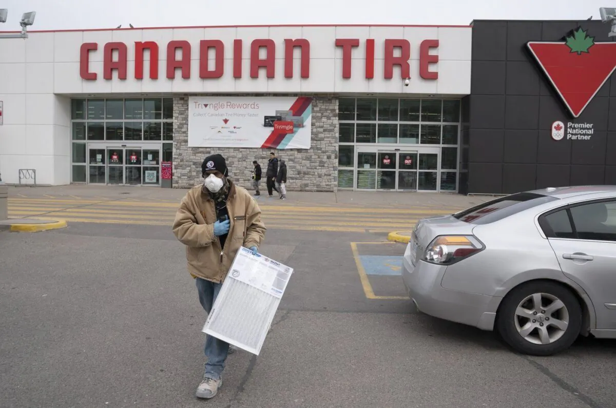 A man wearing a mask walks out of a Canadian Tire store in Toronto on Mar. 18, 2020. (The Canadian Press/Frank Gunn)
