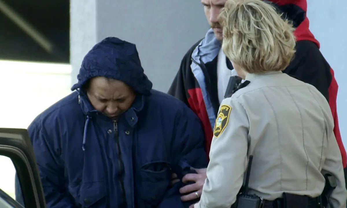 Alfonso Rodriguez Jr. (L) is helped into a sheriff's car after waiving extradition at the Polk County Courthouse in Crookston, Minn., on Dec. 3, 2003. (Ann Heisenfelt/AP Photo)