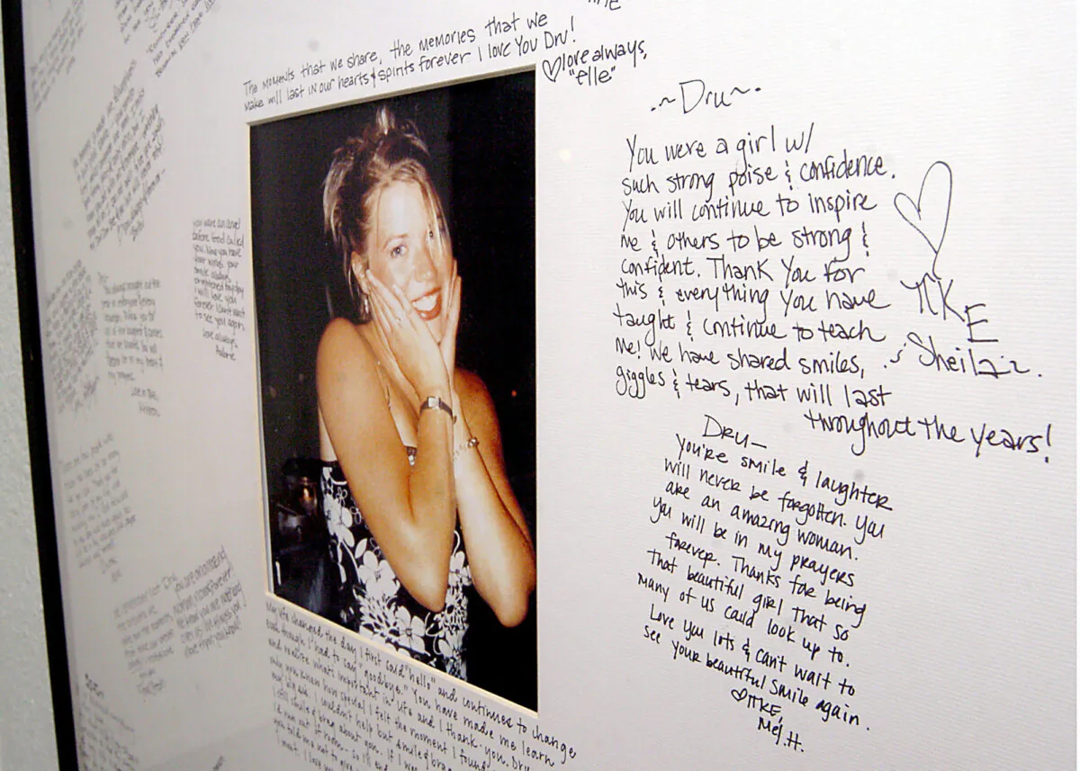 A memorial with a photo of Dru Sjodin and handwritten notes from fellow sorority members hangs in the entry of the Gamma Phi Beta house on the University of North Dakota campus in Grand Forks, N.D., on Nov. 18, 2004. (Kory Wallen/AP Photo)