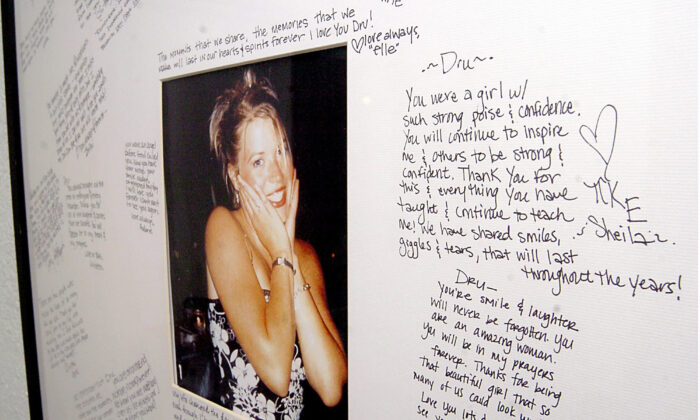 A memorial with a photo of Dru Sjodin and handwritten notes from fellow sorority members hangs in the entry of the Gamma Phi Beta house on the University of North Dakota campus in Grand Forks, N.D., on Nov. 18, 2004. (Kory Wallen/AP Photo)
